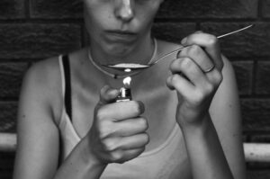 woman cooking heroin b&w