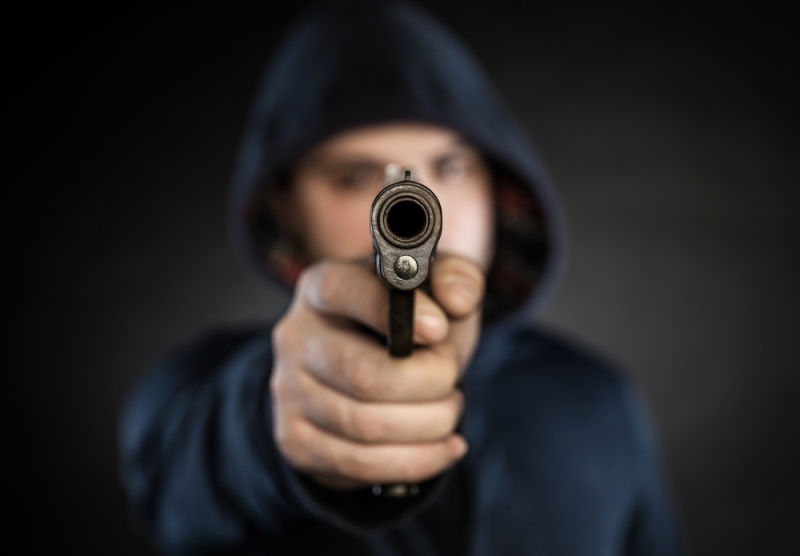 hooded man pointng gun