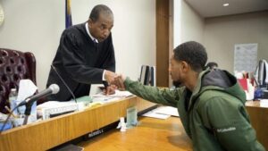 judge shakes hands with student