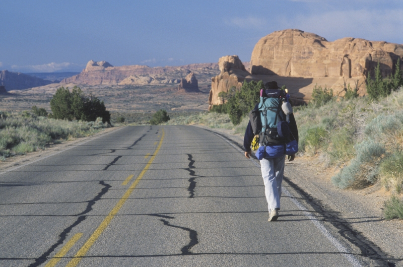 man backpacking highway