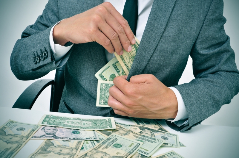 man stuffiing bills in suit