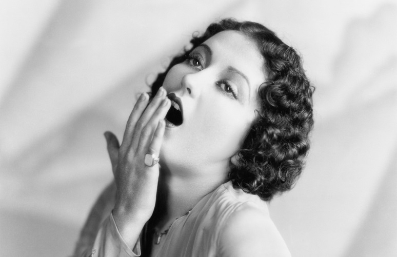 A woman yawning.