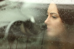 Woman looking out steamy window.