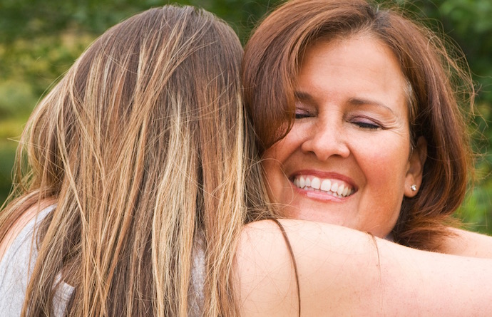 A mother and daughter embracing.