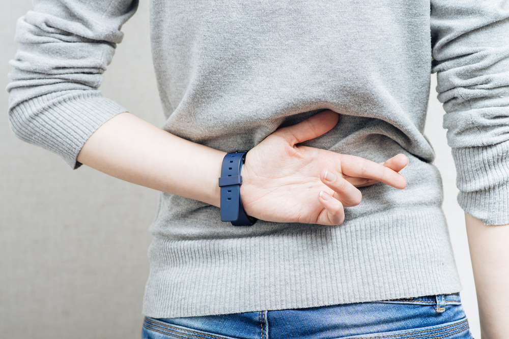 crossed fingers behind back