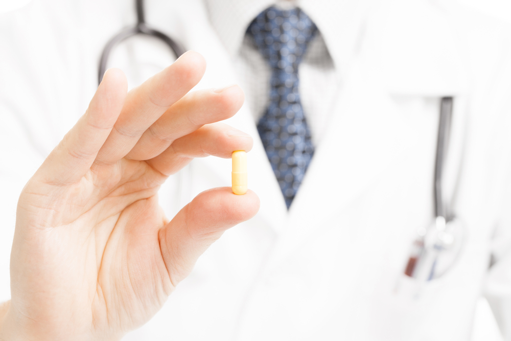 Doctor holding pill.