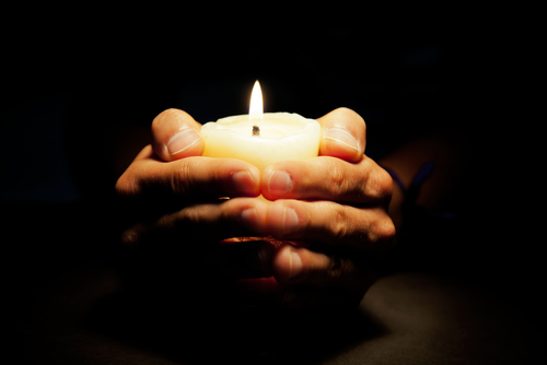 Hands holding a candle.