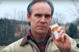 Man holding prescription medication bottle.