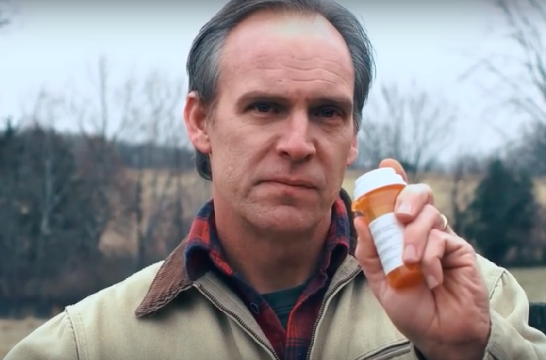 Man holding prescription medication bottle.