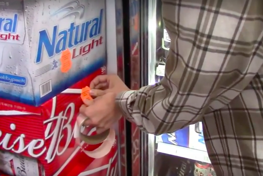 Man placing sticker on beer packaging.
