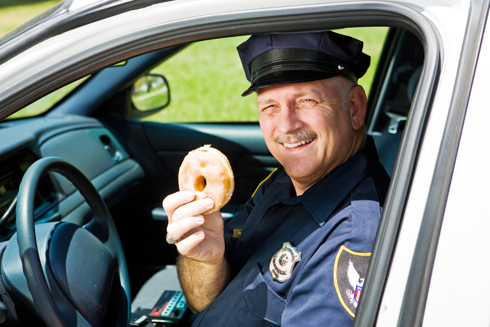 Policeman holding donut.