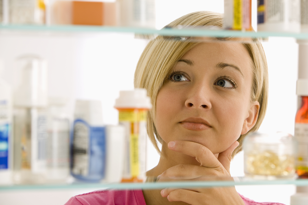 Woman looking in medicine cabinet.