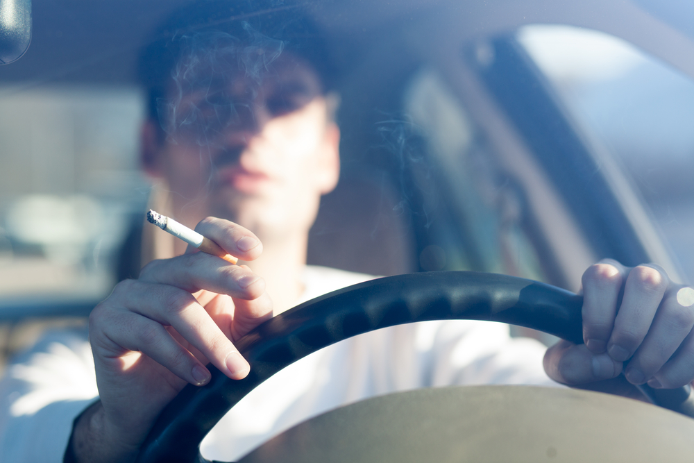 Man smoking in car.