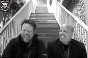 Kurtis Matthews and Mark Lundholm sitting on a staircase, black and white