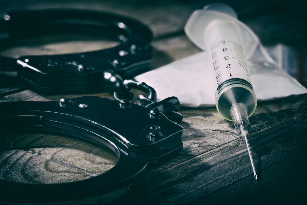 Drugs and handcuffs on a table.