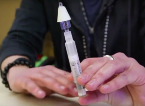 Woman holding naloxone injector.