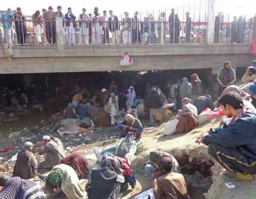 Afghans converging near a bridge.