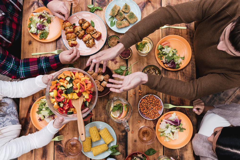 Friends having dinner around a big table.