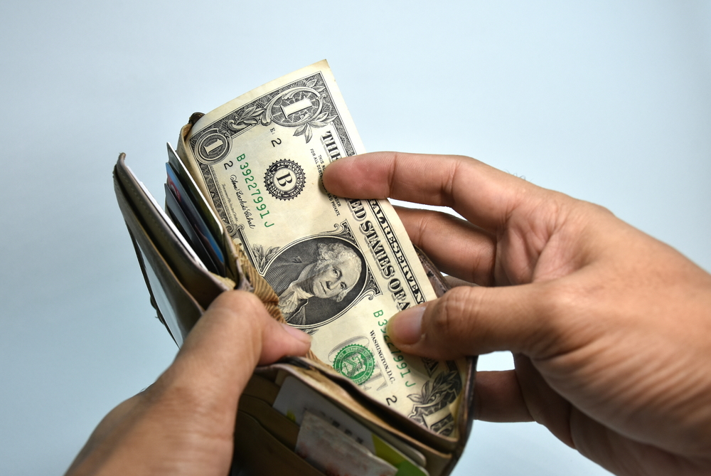 Man opening wallet filled with money.