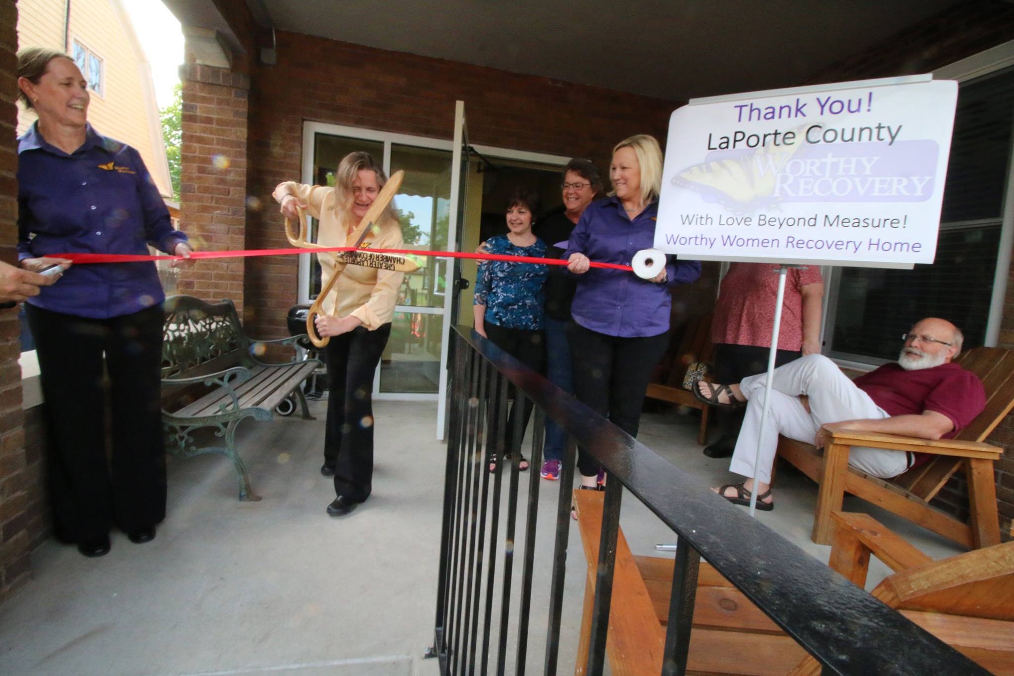 Women Ribbon Cutting Outside New Building