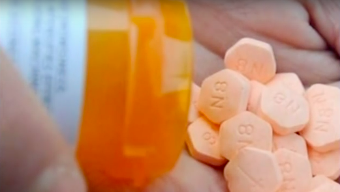 A closeup of Suboxone tablets being poured into a hand from a prescription bottle.