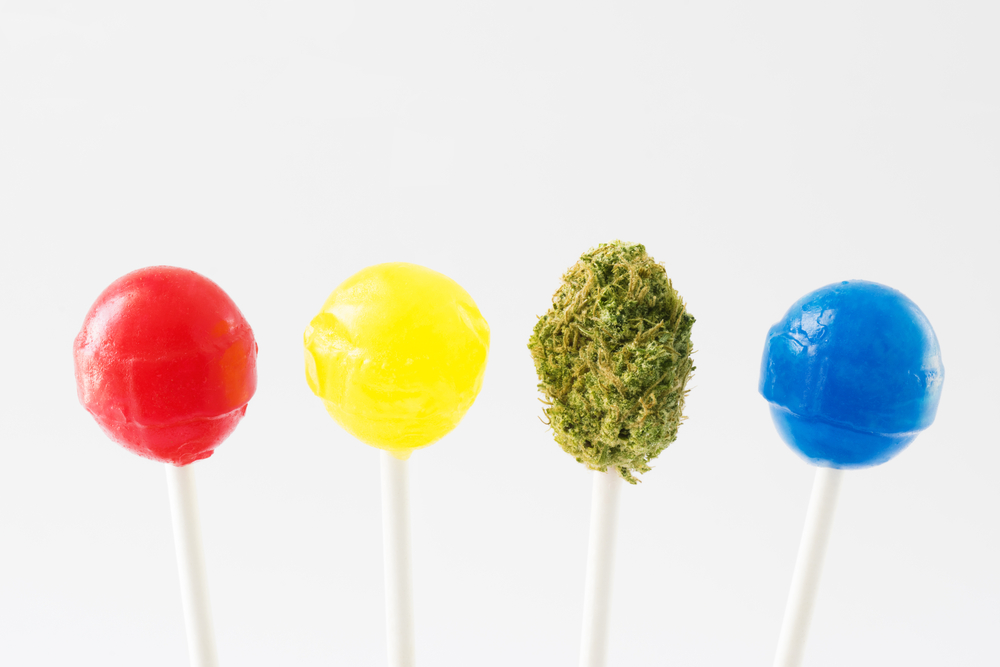 a red lollipop, a yellow lollipop, a lollipop with a marijuana bud and a blue lollipop