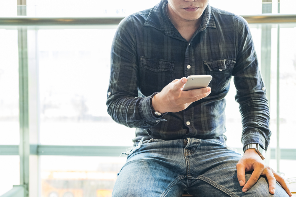 A man texts on the phone.