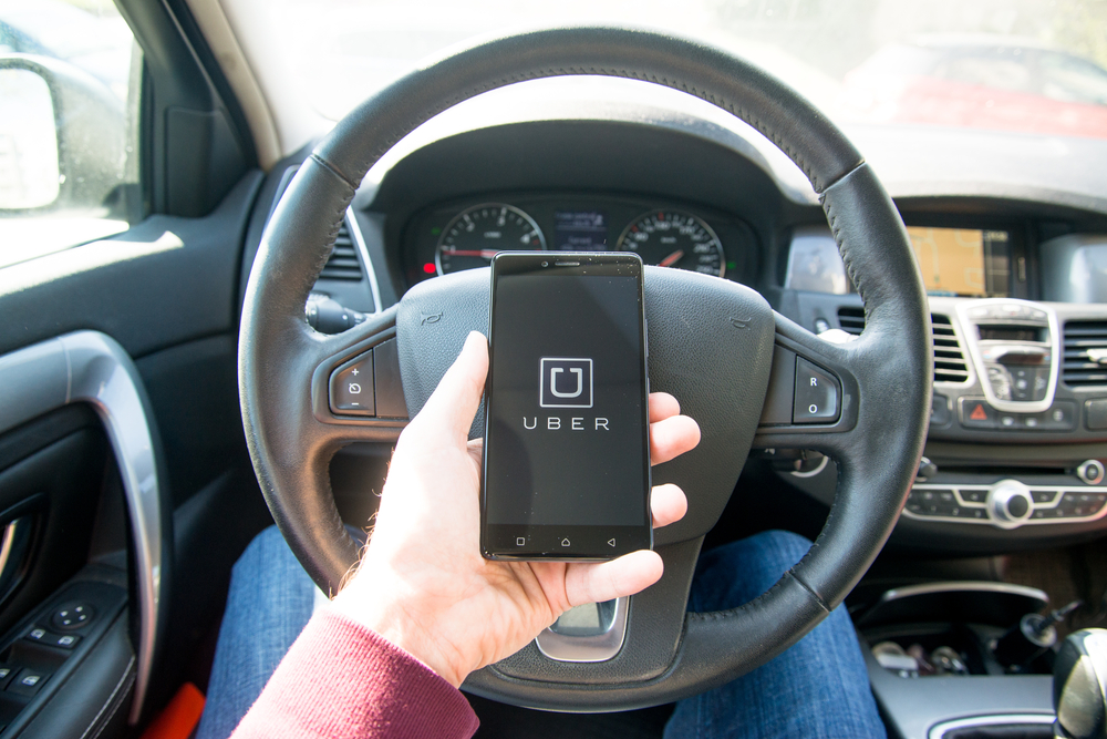 driver with uber app opened on their smartphone.