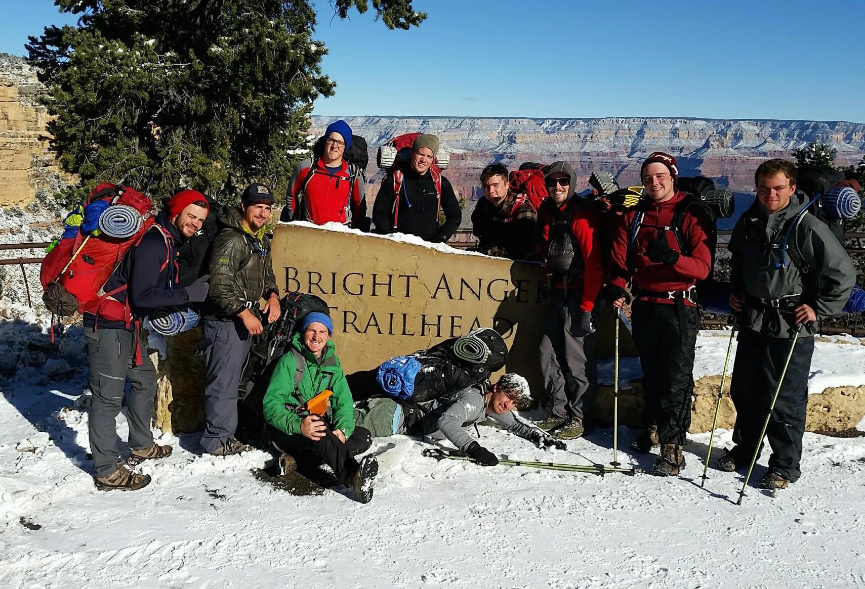 A group of men in front of Bright Angel Trailhead sign, in the snow.