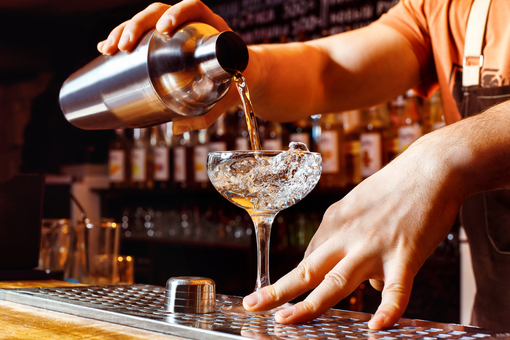 bartender pouring a drink on the bar counter.