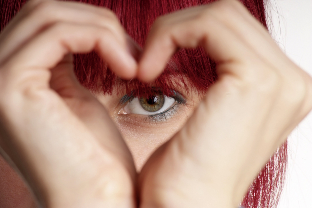 Woman forming hands in a heart shape.