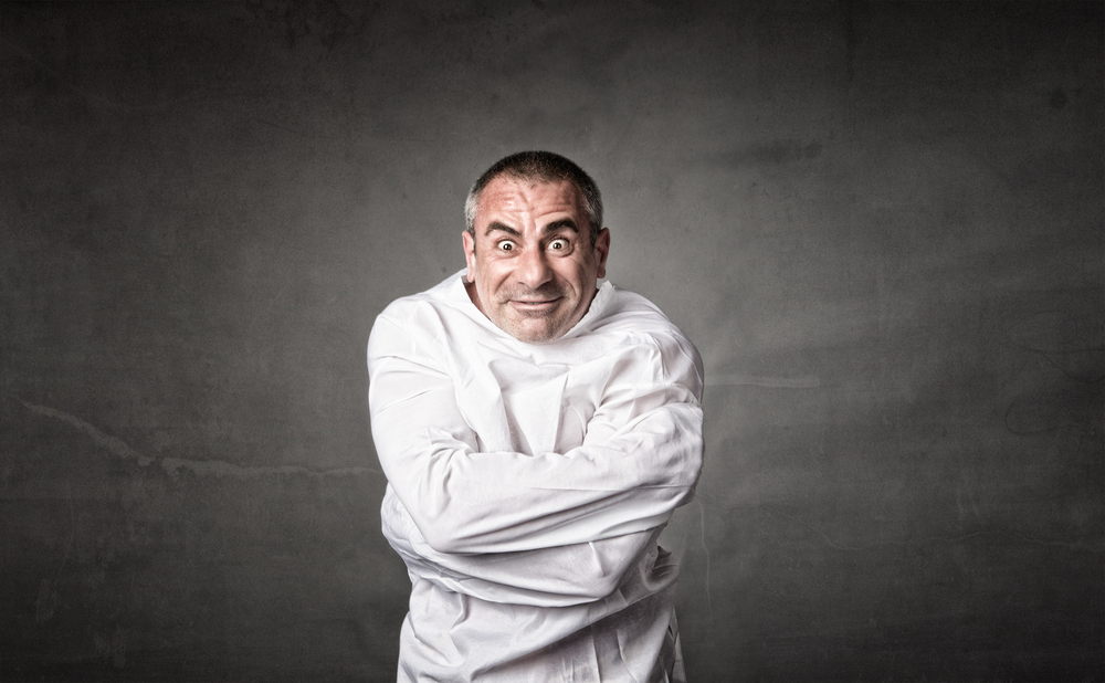 Man in strait jacket on a dark background.