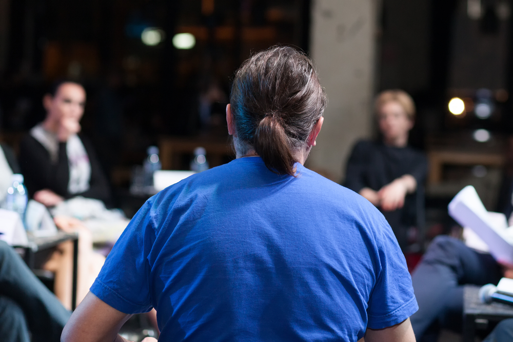 man with ponytail sitting at roundtable discussion
