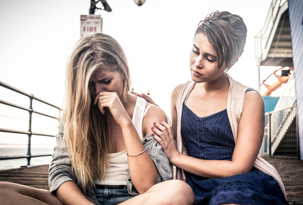 teen girl consoling her sad friend