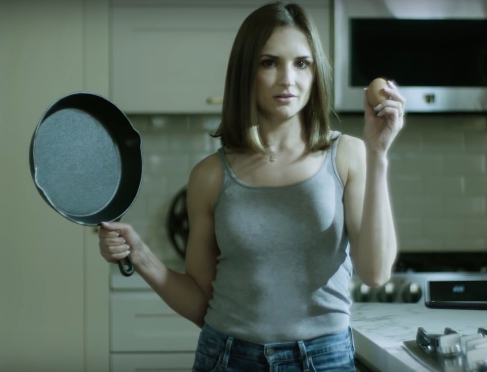 Rachel Leigh Cook holding an egg and a frying pan in new PSA