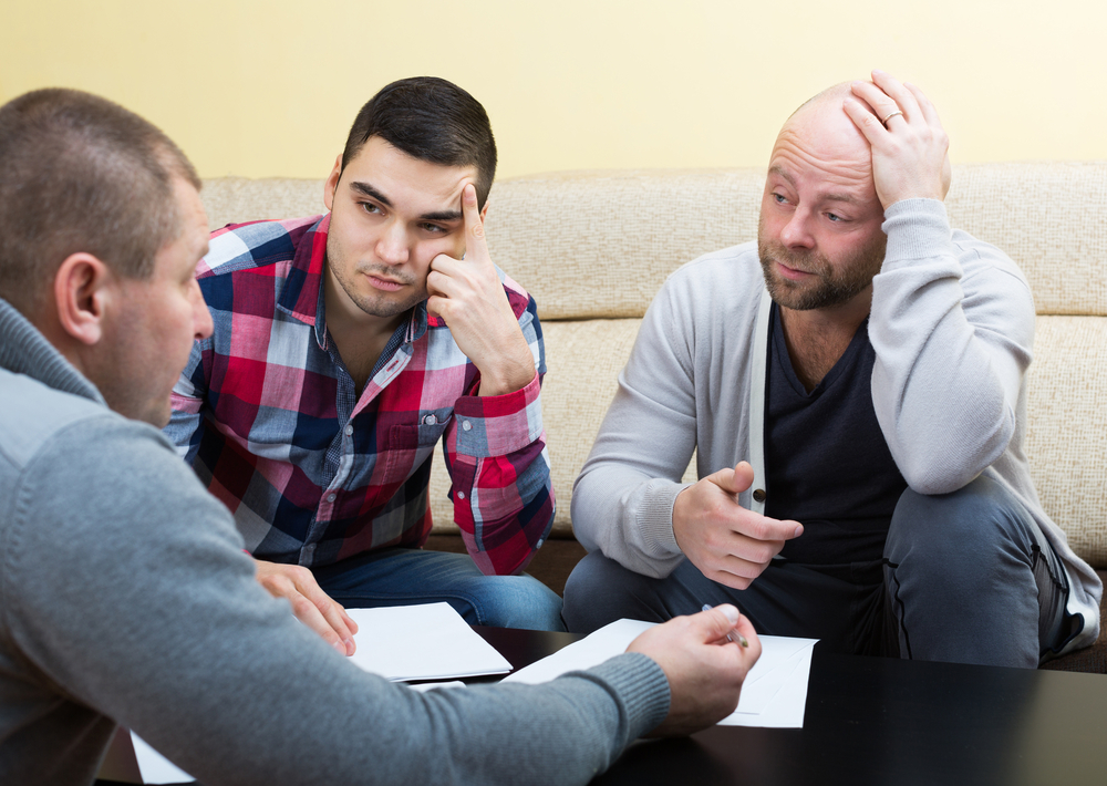 Two men talking to a counselor.