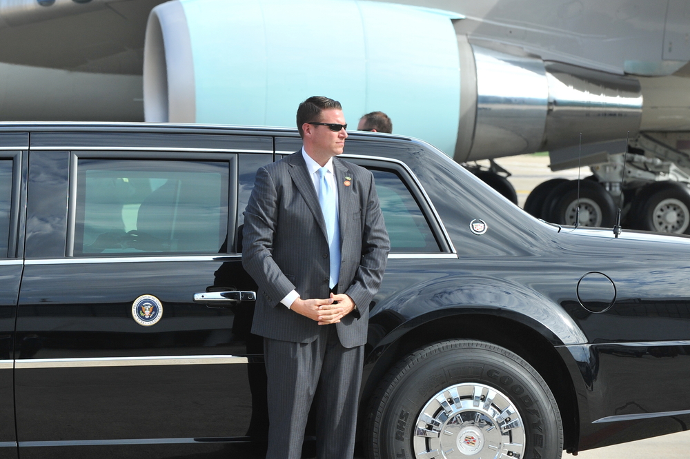 an unidentified agent stands by the president's car.