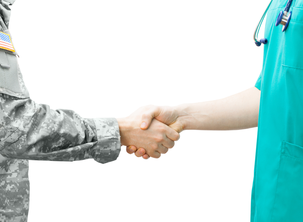 A doctor shaking hands with a soldier in uniform