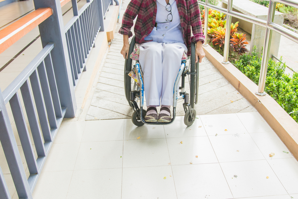 woman in wheelchair using the ramp to access building