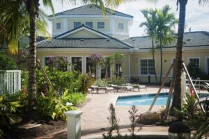 Futures of Palm Beach building and swimming pool with palm trees.