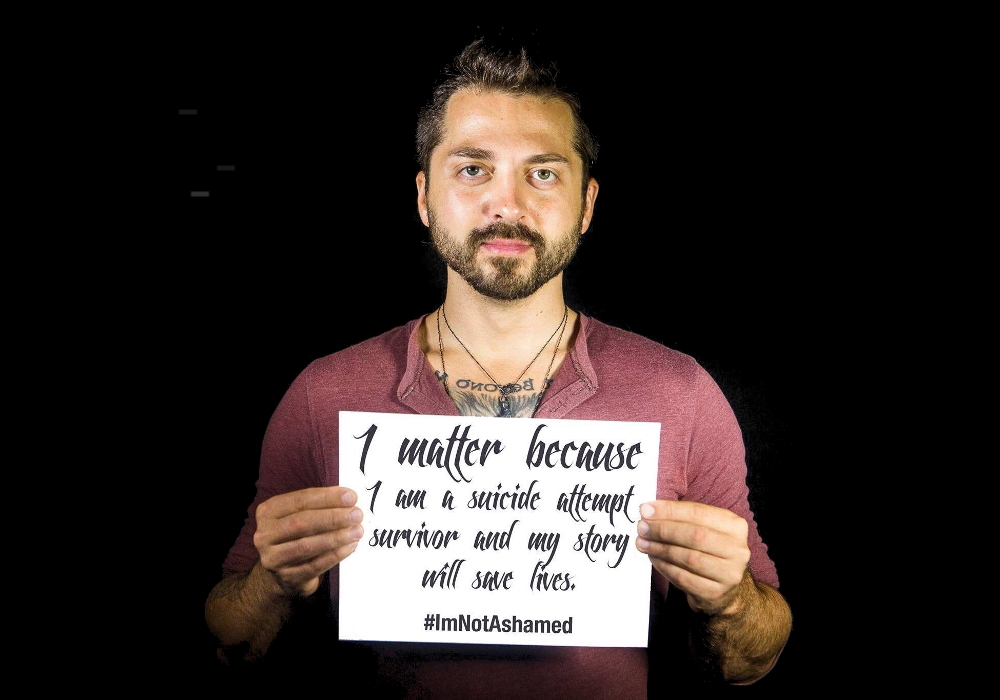 Joseph Penola of You Rock holding a sign to share his story.