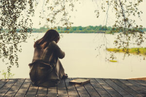 woman sitting alone by the water