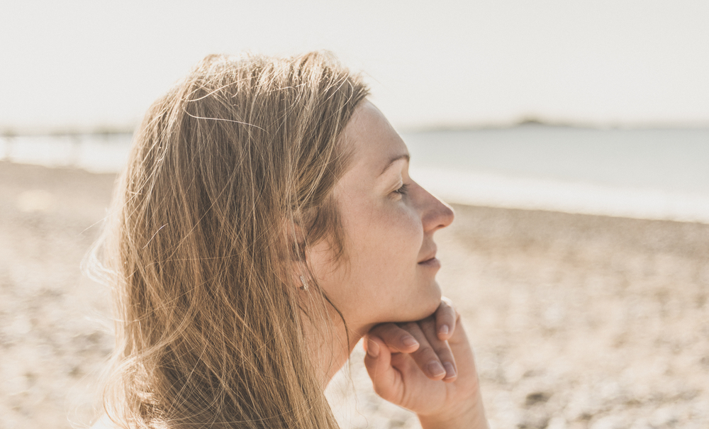 happy thoughtful woman looking out to sea