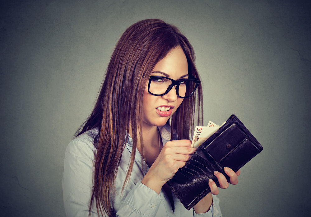 young woman removing cash from her wallet