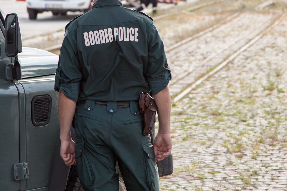 border patrol officer standing by his vehicle