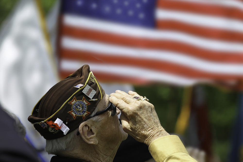 a veteran saluting an American flag