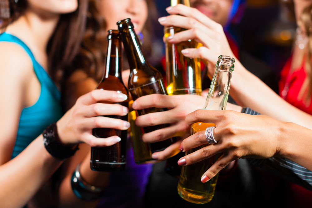 a group of women holding beer bottles