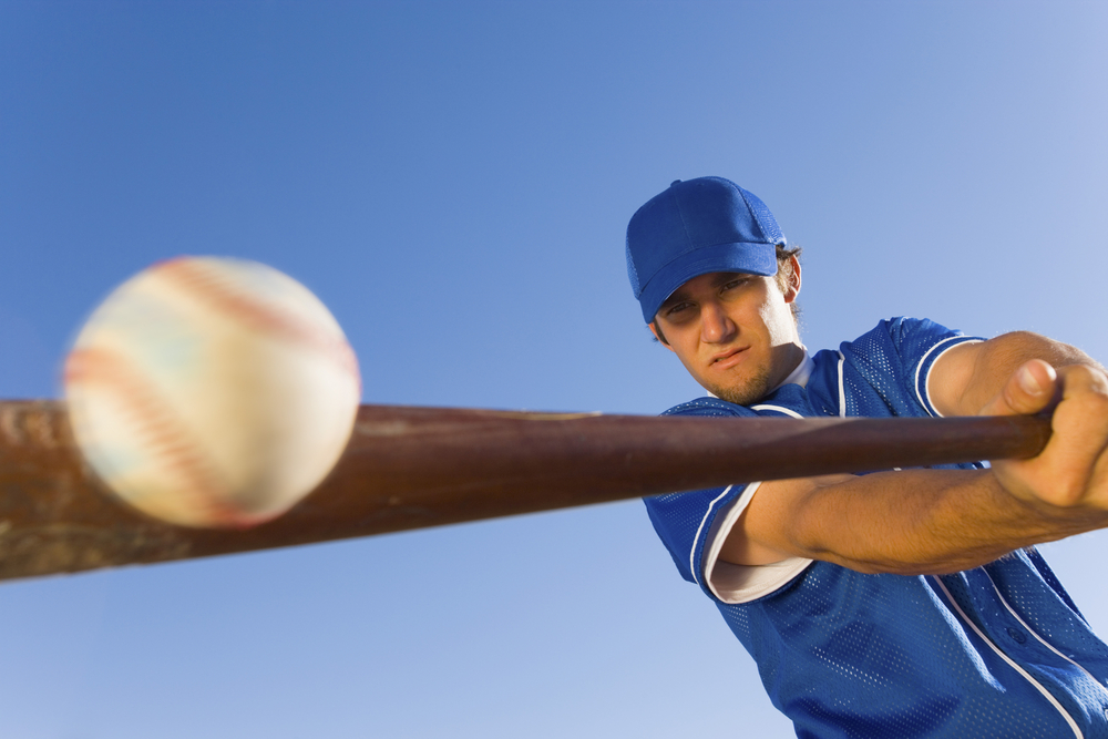 baseball player swimming a bat into a ball