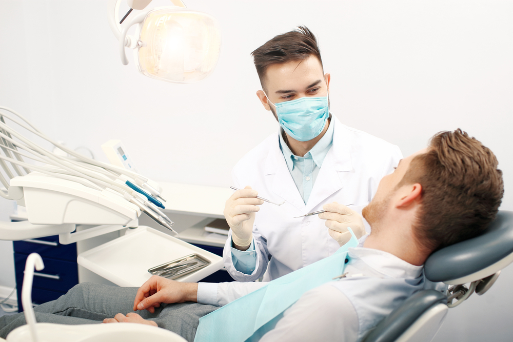 Male dentist working on patient in dental chair