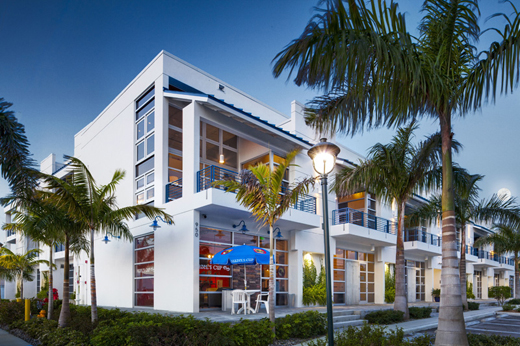 Hazelden’s Naples, Florida facility: a white building with balconies and a lot of glass, surrounded by palm trees.